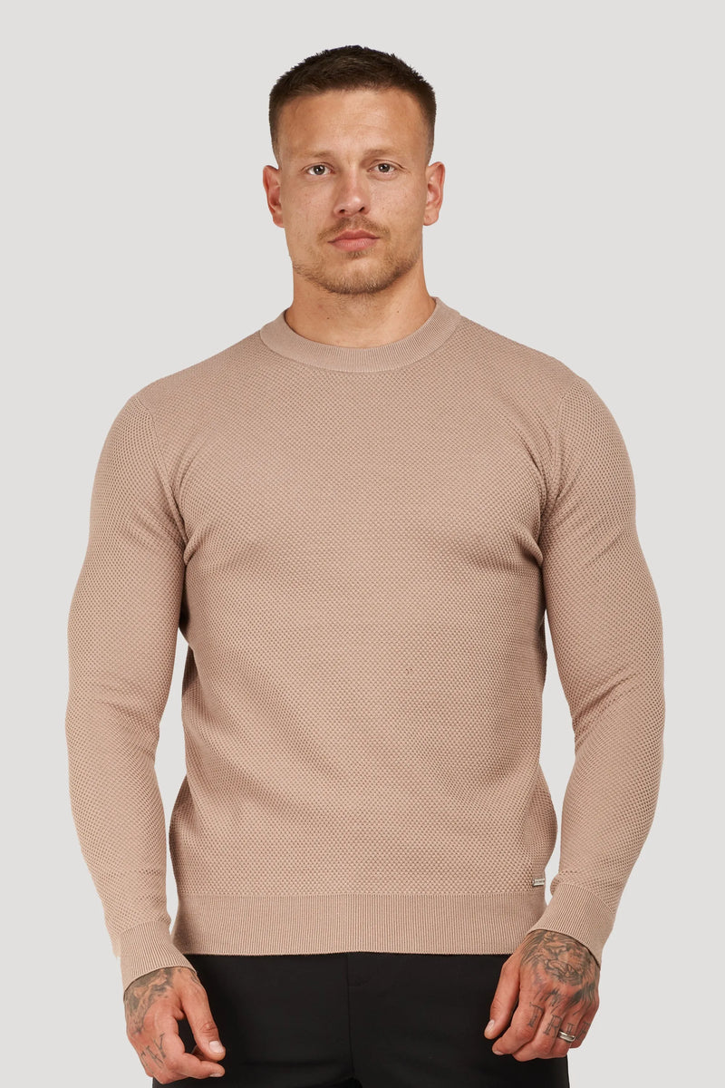 Man wearing a beige textured crew neck sweater