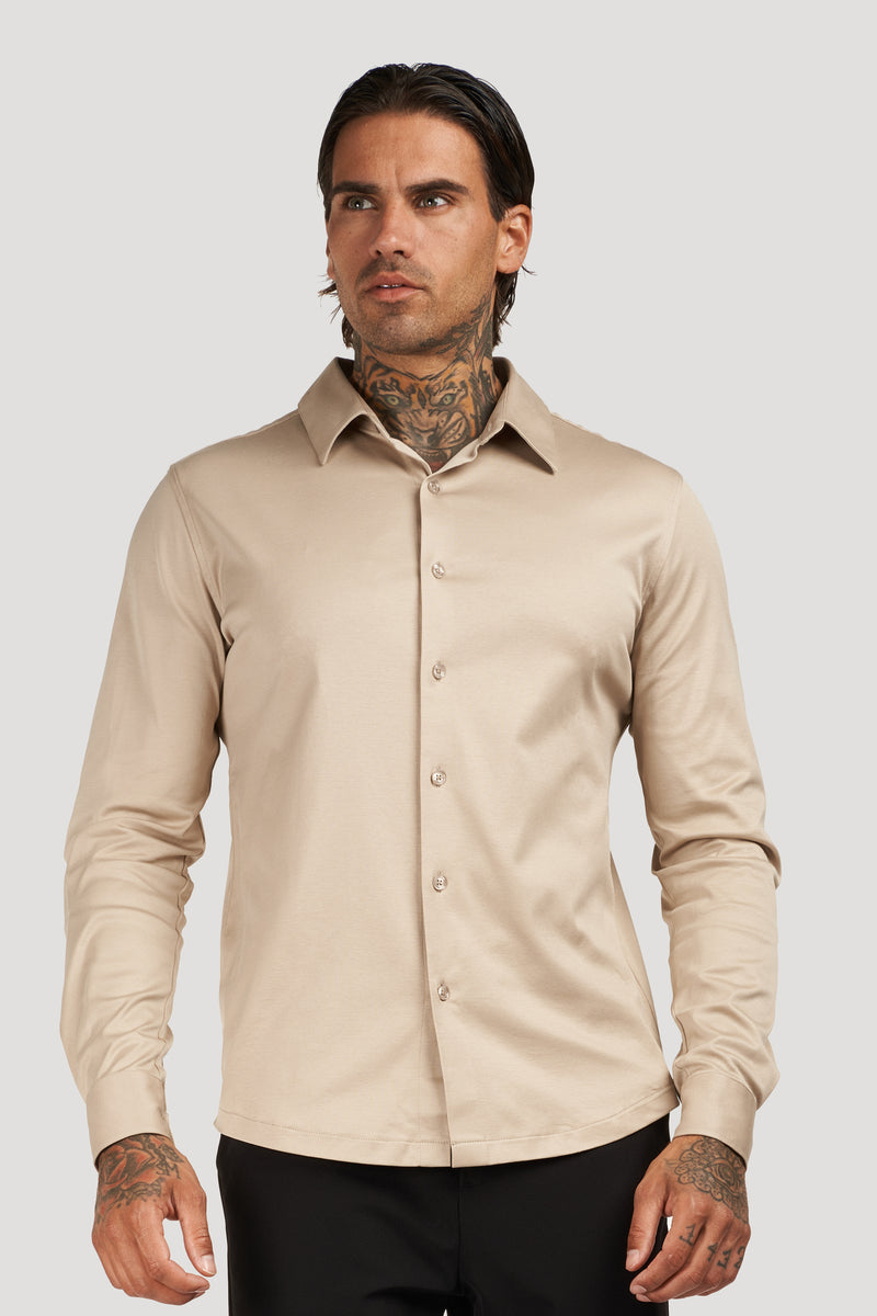 Man wearing a beige long-sleeve button-up shirt with a collar