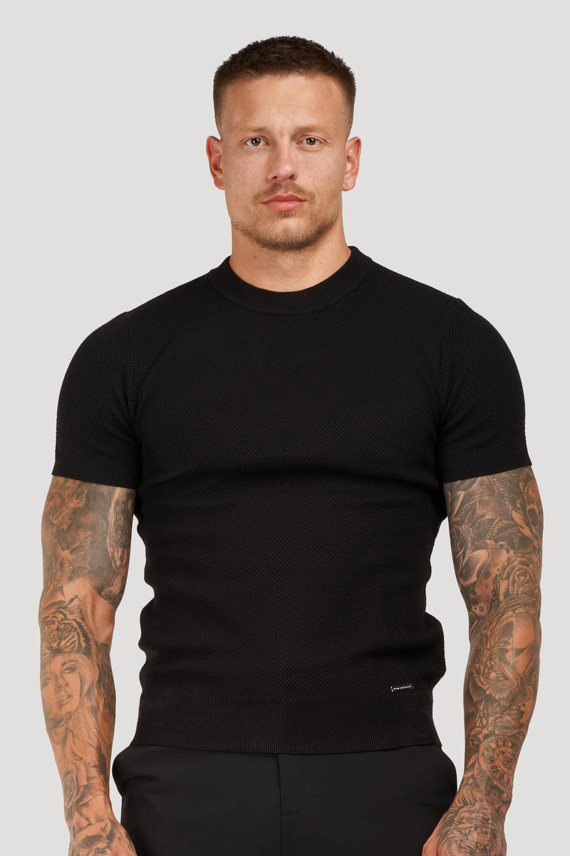 Man wearing a fitted black textured short-sleeve t-shirt